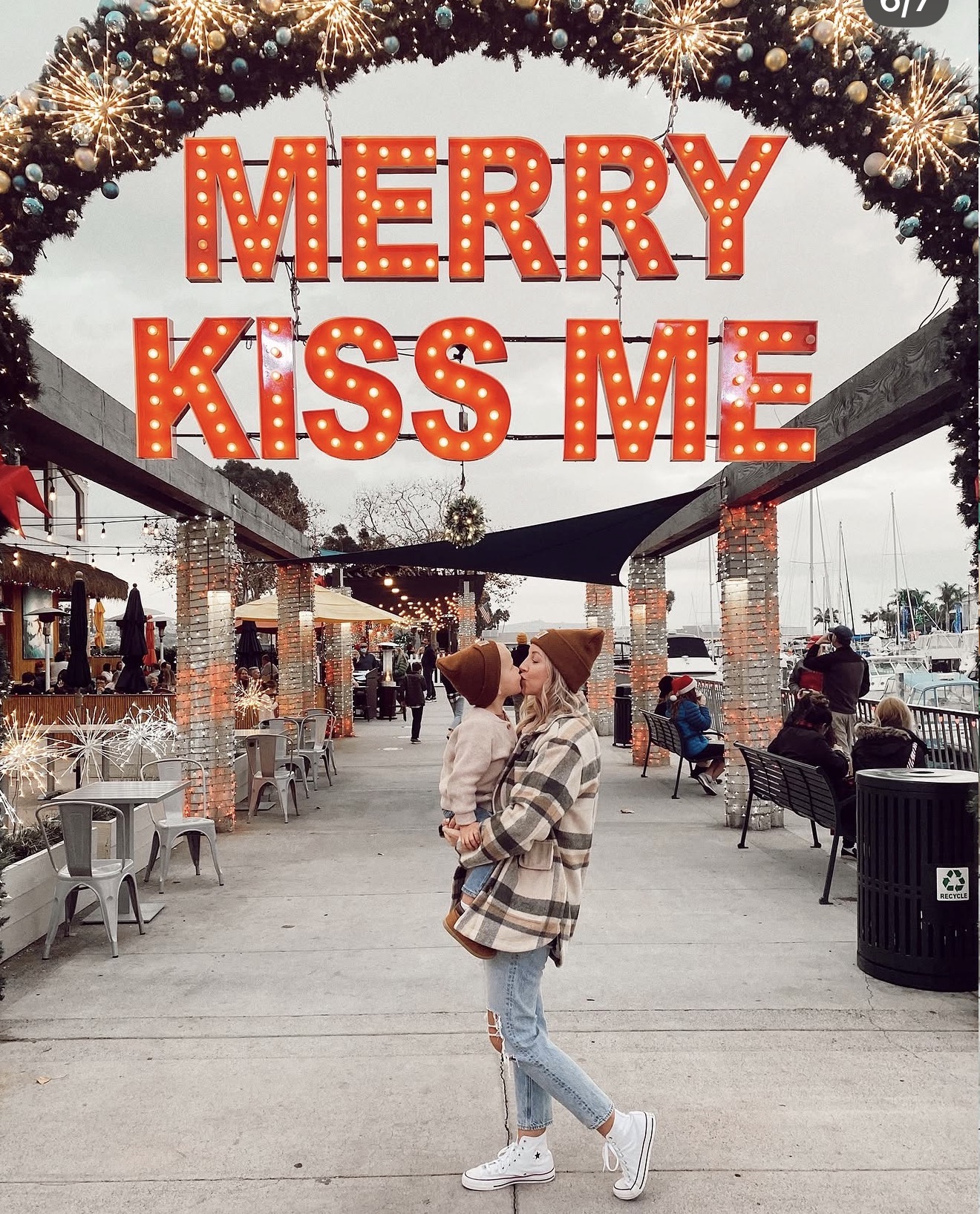 Mother and child posing under Merry Kiss Me