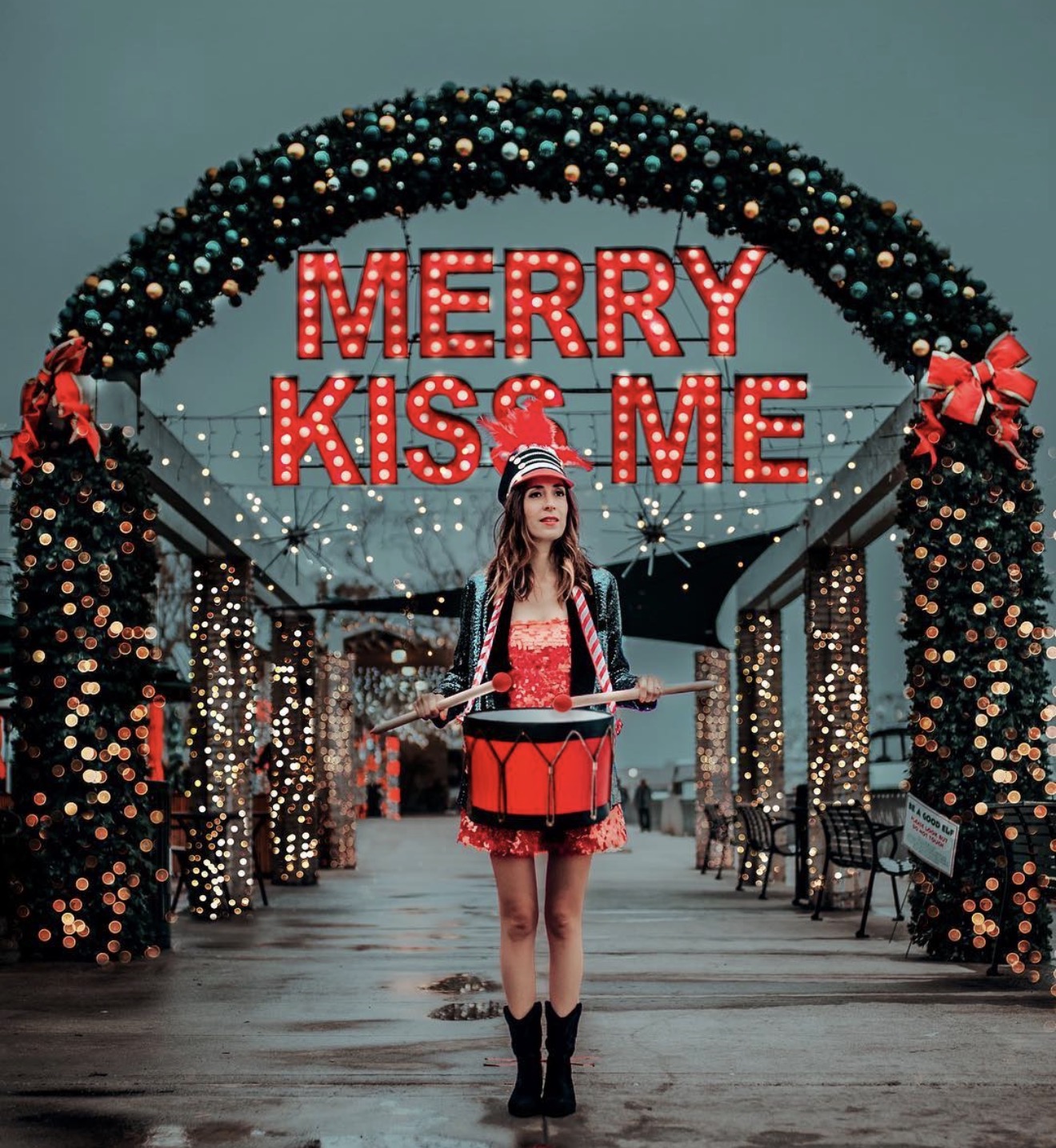 Holiday performer in front of Merry Kiss Me
