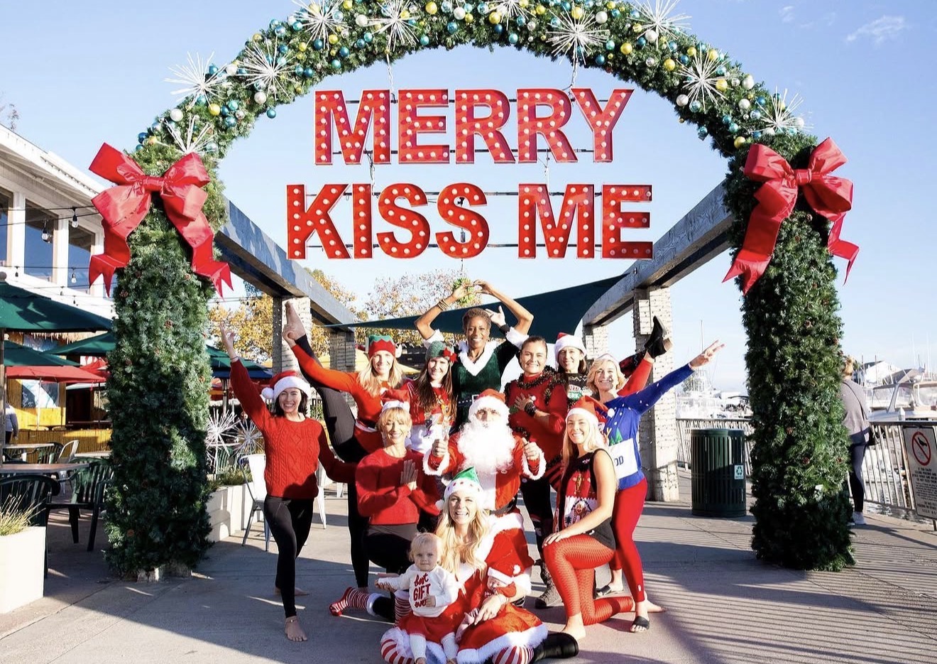 Group posing with Santa under Merry Kiss Me